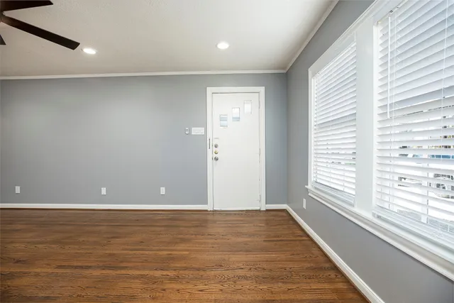 a view of an empty room with wooden floor