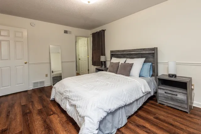 a bedroom with bed and wooden floor
