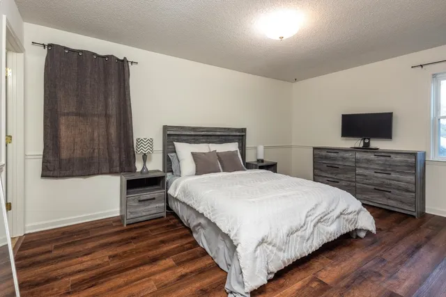 a bedroom with a bed and a flat screen tv