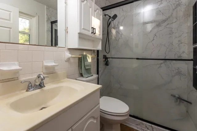 a bathroom with a sink toilet and mirror