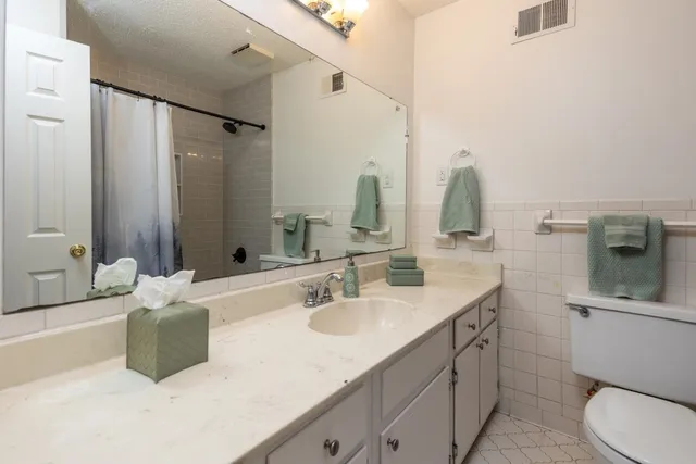 a bathroom with a double vanity sink mirror and toilet