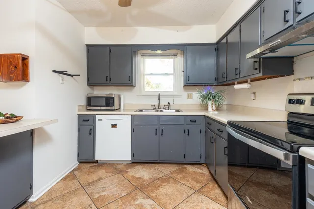 a kitchen with cabinets appliances a sink and a window