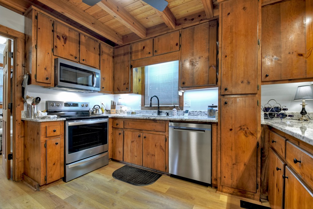 392 Eagles Nest Mountain Road Blue Ridge, GA 30513 - Photo 17 of 51 a kitchen with granite countertop stainless steel appliances and wooden cabinets