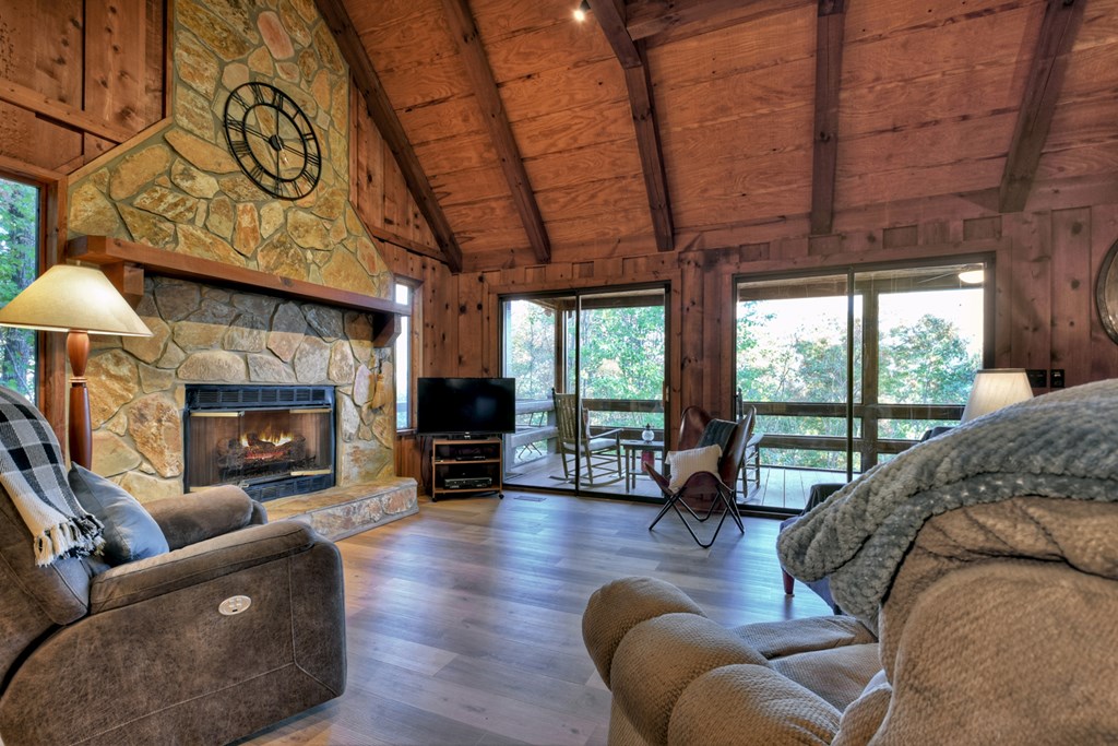 392 Eagles Nest Mountain Road Blue Ridge, GA 30513 - Photo 10 of 51 a living room with furniture a fireplace a flat screen tv and a large window
