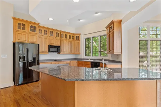 a kitchen with stainless steel appliances granite countertop a sink a stove and a refrigerator