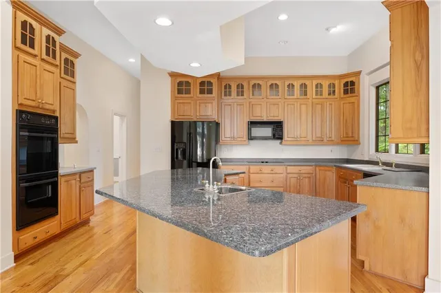 a kitchen with stainless steel appliances granite countertop a sink a oven and a granite counter tops with white cabinets