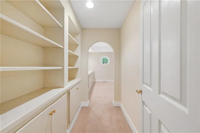a hallway with white doors wooden floor and front door