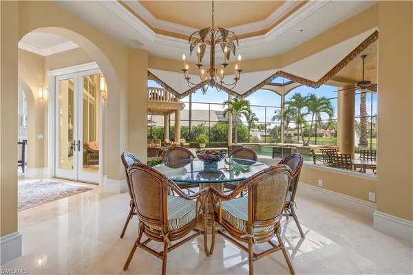 a dining room with furniture a chandelier and wooden floor
