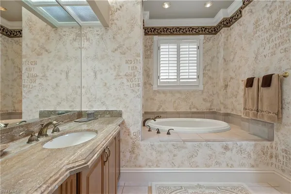 a bathroom with a granite countertop sink and a bathtub