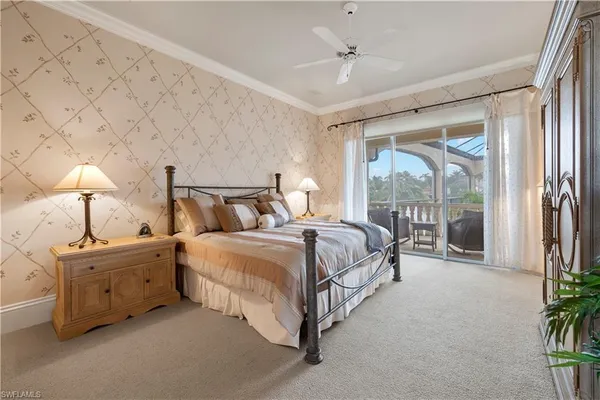 a bedroom with a large bed and a chandelier fan