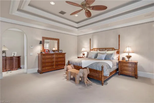 a spacious bedroom with a bed and a chandelier