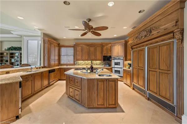 a kitchen with stainless steel appliances granite countertop a stove a sink and a refrigerator