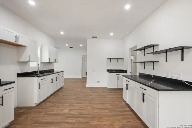 a large kitchen with stainless steel appliances granite countertop a stove and a sink