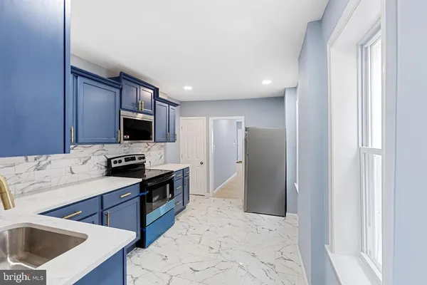 a kitchen with stainless steel appliances kitchen island granite countertop a refrigerator a sink a stove a microwave and island