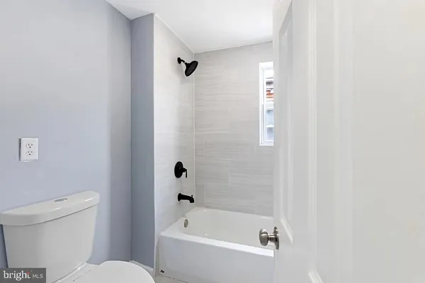 a white bath tub sitting next to a toilet