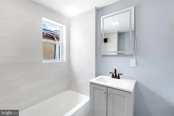 a bathroom with a sink a mirror and a bathtub