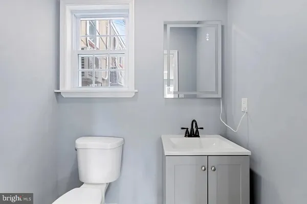 a bathroom with a toilet sink and mirror