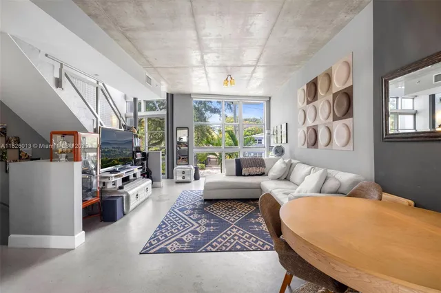 a living room with furniture fireplace and a large window