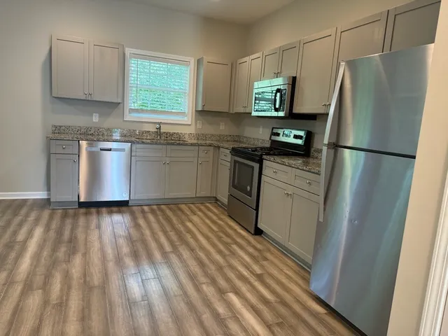 a kitchen with stainless steel appliances a refrigerator sink and microwave