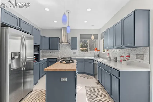 a kitchen with stainless steel appliances granite countertop a sink stove refrigerator and cabinets