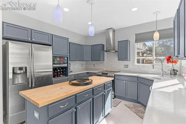 a kitchen with a sink a counter top space stainless steel appliances and cabinets