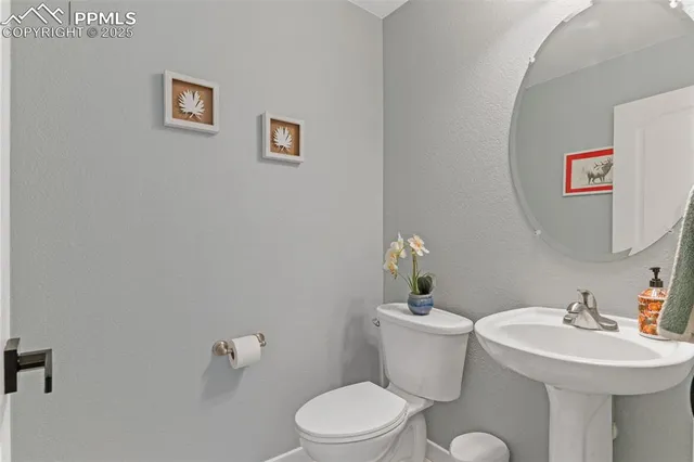 a bathroom with a sink mirror and a toilet
