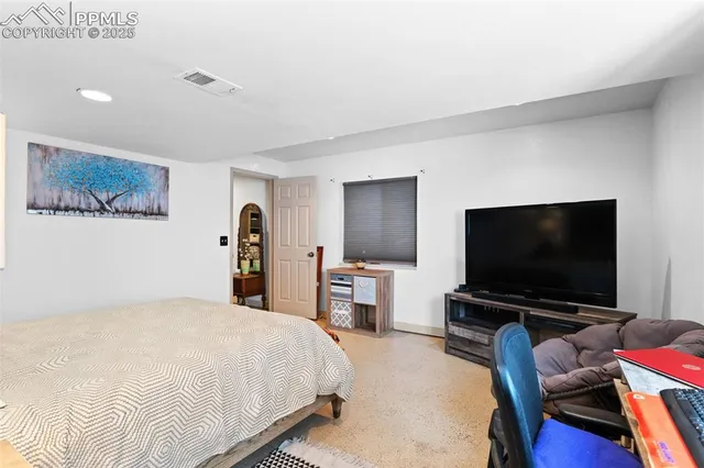 a bedroom with a bed and a flat screen tv