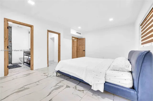 a spacious bedroom with a bed and a cabinets