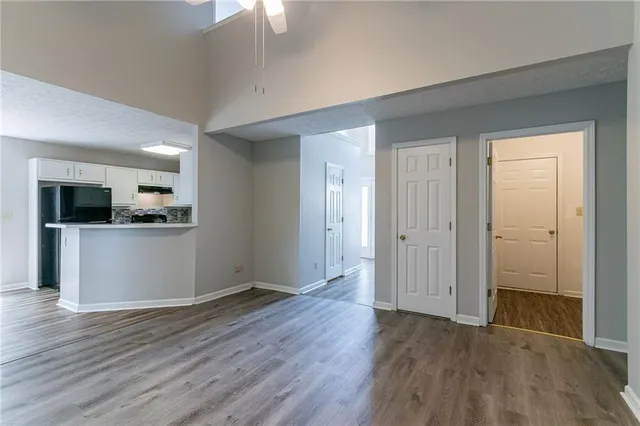 an empty room with wooden floor and windows