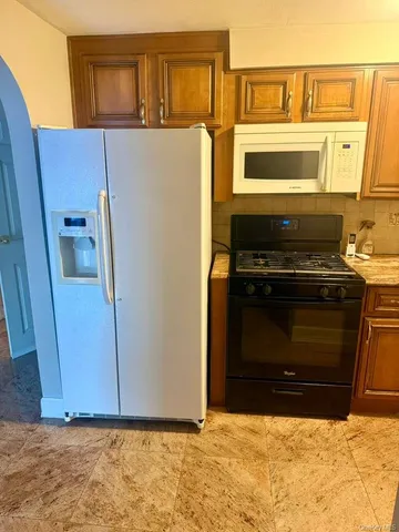 a view of a kitchen with a stove top oven and cabinets