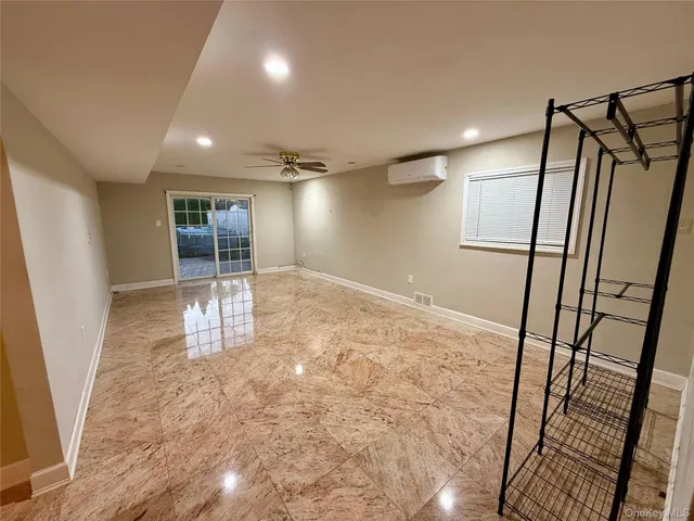 en empty room with wooden floor and fan