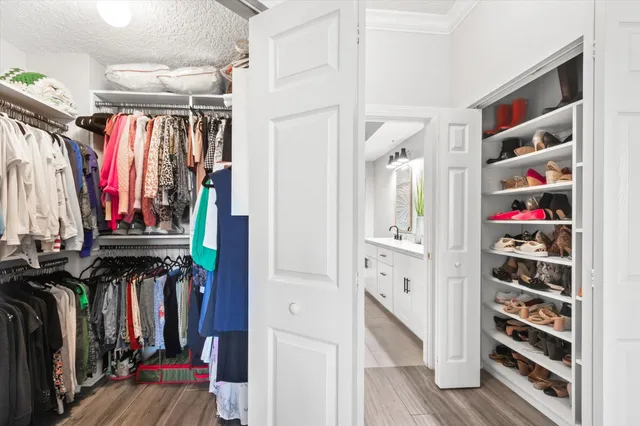 a view of walk in closet with clothes and shoes