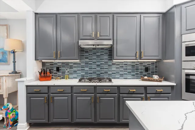 a kitchen with stainless steel appliances granite countertop a sink stove and cabinets