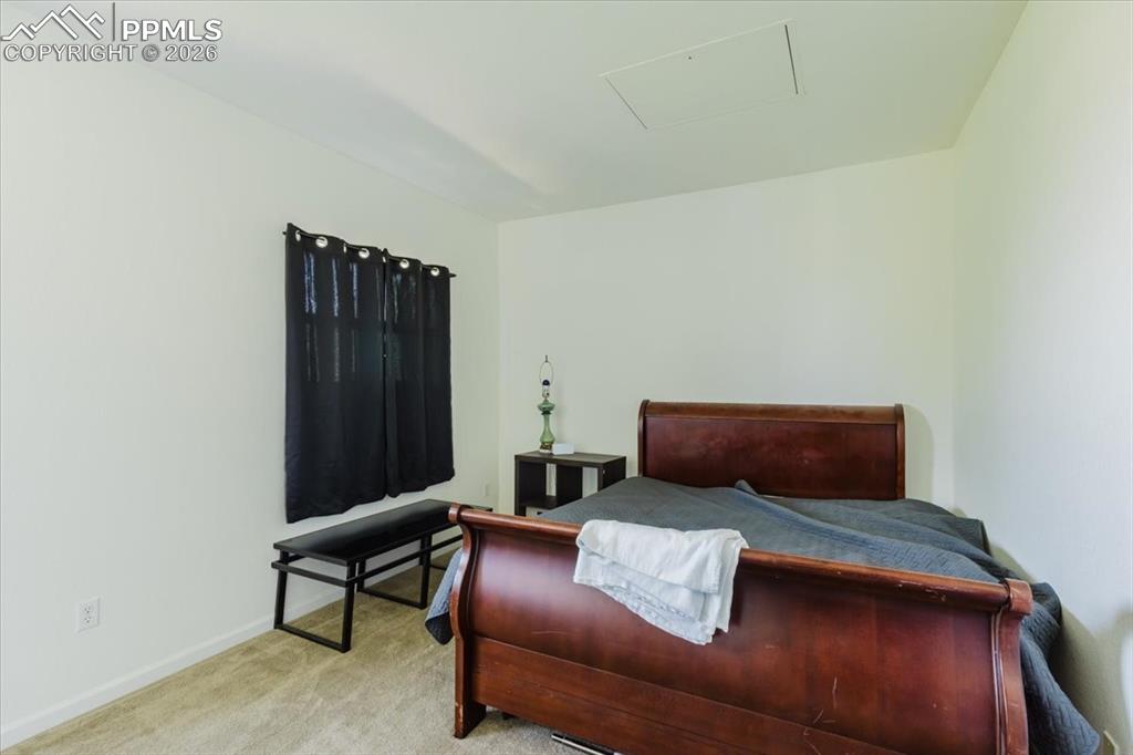 5800 Tower Road, Unit 108 Denver, CO 80249 - Photo 11 of 35 Carpeted room featuring a window with dark curtains, white walls, and a ceiling access panel