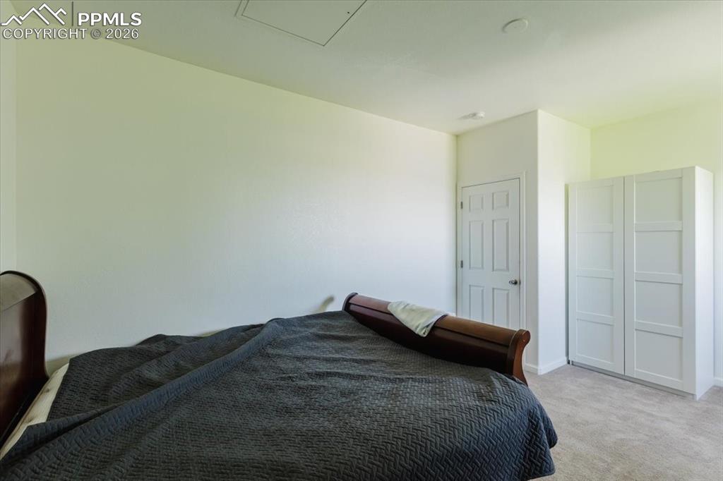 5800 Tower Road, Unit 108 Denver, CO 80249 - Photo 12 of 35 Carpeted room with a six-panel interior door and a white built-in wardrobe