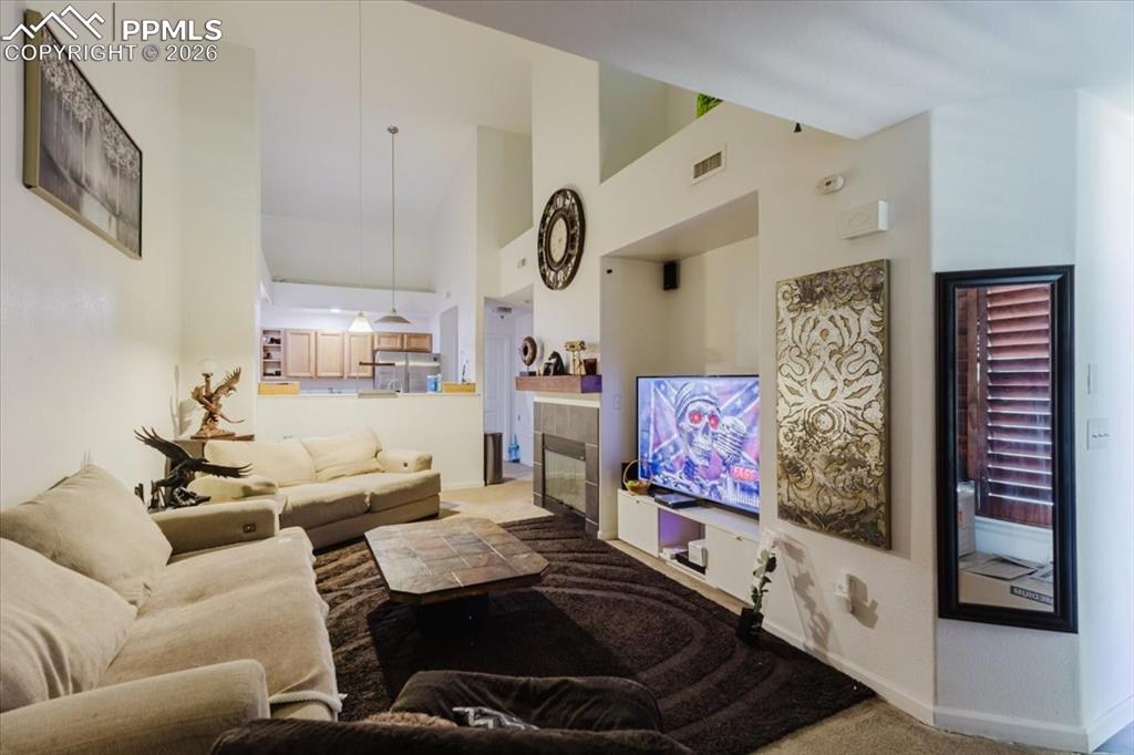 5800 Tower Road, Unit 108 Denver, CO 80249 - Photo 15 of 35 Vaulted ceilings enhance this open-concept living space, featuring a built-in media niche with a fireplace