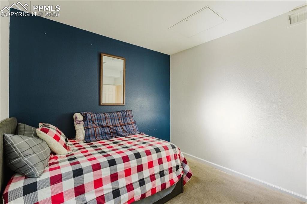 5800 Tower Road, Unit 108 Denver, CO 80249 - Photo 16 of 35 Carpeted room featuring a dark accent wall, white textured walls, white trim, and a ceiling access panel