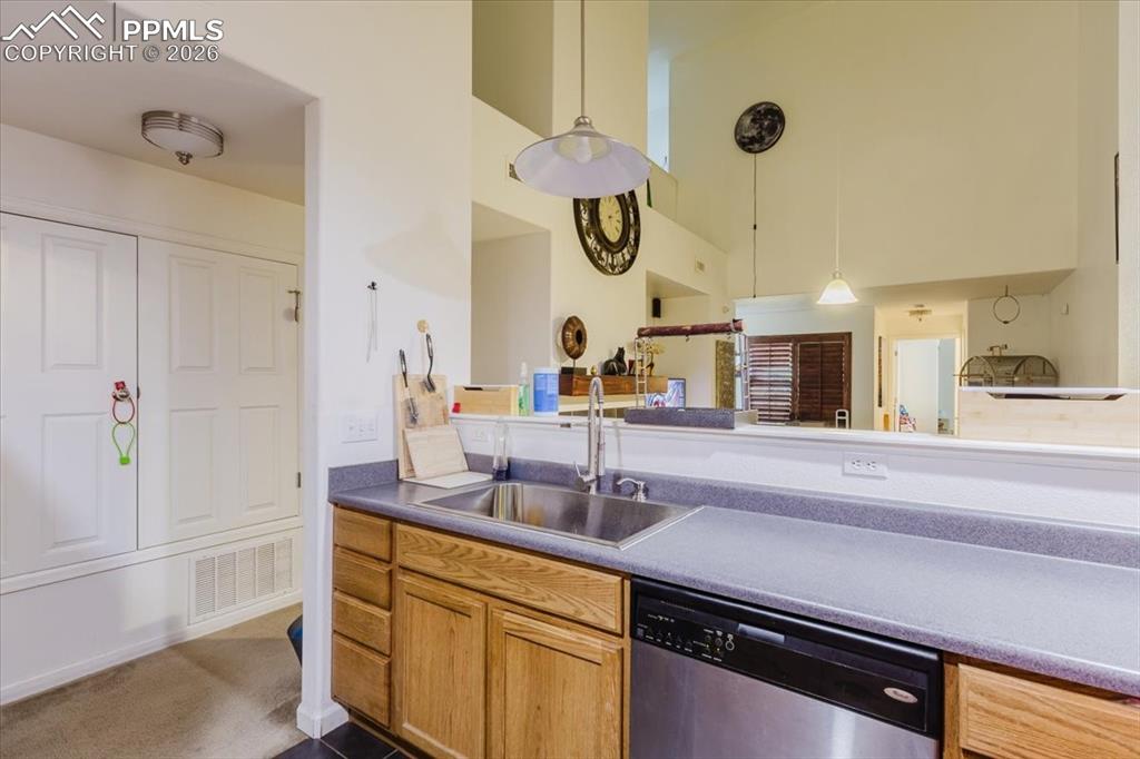5800 Tower Road, Unit 108 Denver, CO 80249 - Photo 21 of 35 Kitchen space featuring wood-finish cabinetry, stainless steel sink, and a built-in dishwasher