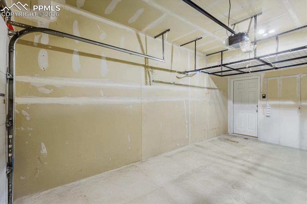 5800 Tower Road, Unit 108 Denver, CO 80249 - Photo 33 of 35 Spacious garage featuring concrete flooring and neutral-toned walls