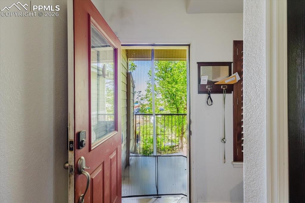 5800 Tower Road, Unit 108 Denver, CO 80249 - Photo 34 of 35 Entryway featuring a red paneled door with an integrated glass panel, a smart lock, and a security screen door leading to an outdoor space