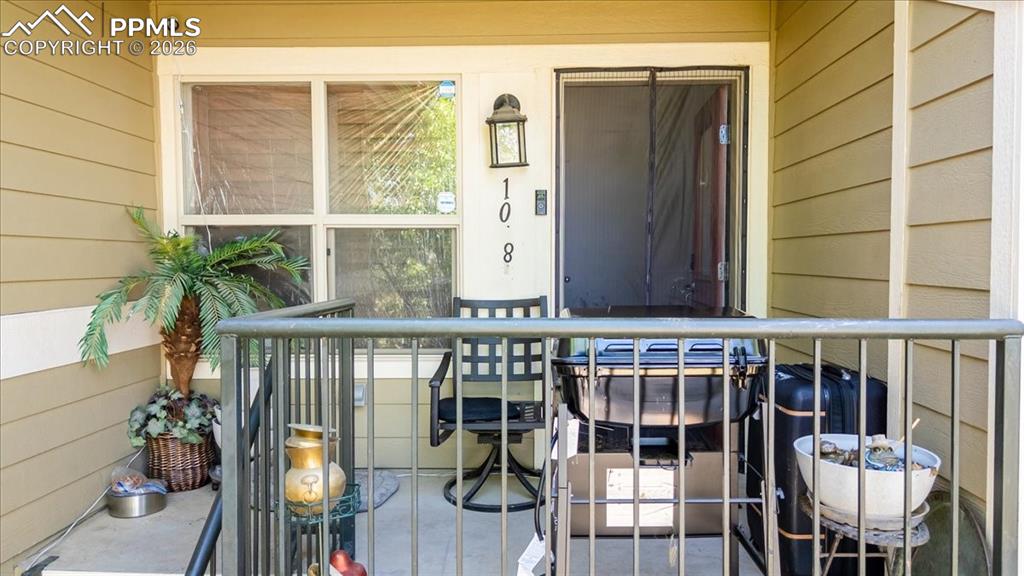 5800 Tower Road, Unit 108 Denver, CO 80249 - Photo 4 of 35 Inviting front porch featuring horizontal siding, a framed window, exterior lighting, and a dark-framed entry door