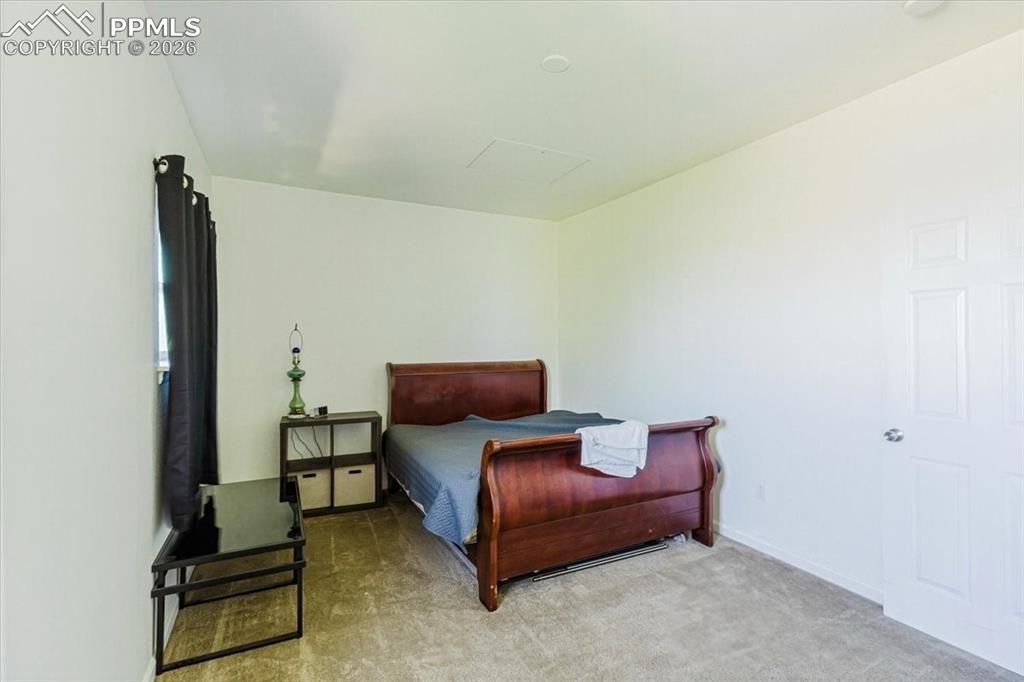5800 Tower Road, Unit 108 Denver, CO 80249 - Photo 10 of 35 Carpeted interior room featuring a window with dark drapes, white walls, and a white paneled door