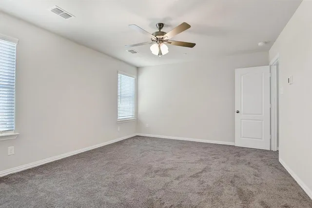 a view of an empty room with a chandelier fan