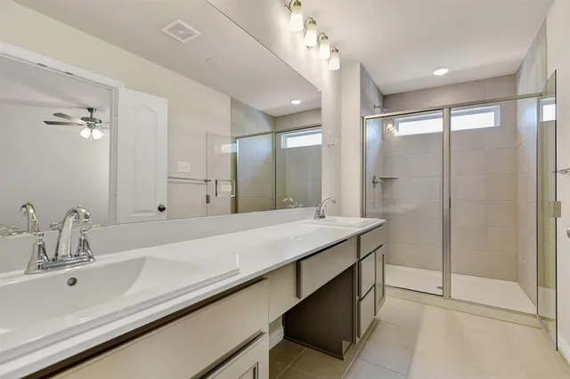 a bathroom with a double vanity sink mirror and shower