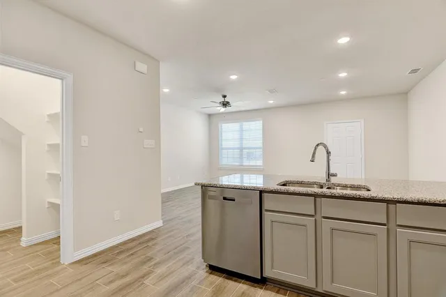 a kitchen with stainless steel appliances granite countertop a stove a sink and a microwave