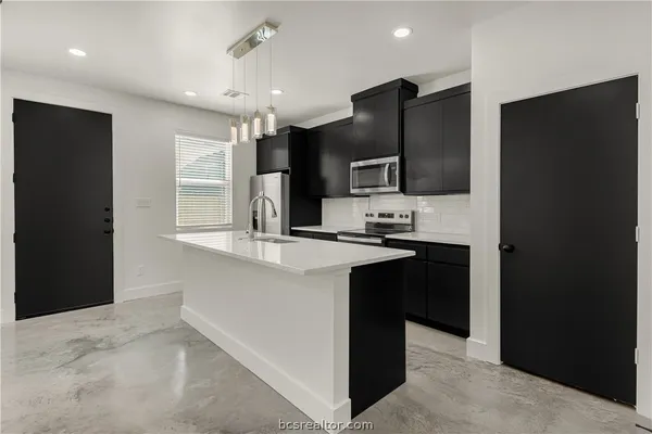 a kitchen with stainless steel appliances granite countertop a refrigerator and a sink