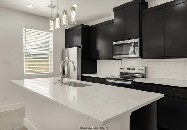 a kitchen with stainless steel appliances a sink microwave and stove