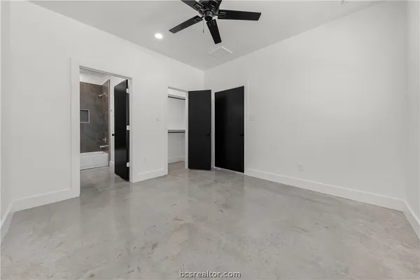 an empty room with a ceiling fan and carpet