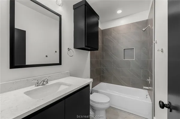 a bathroom with a bathtub shower sink and toilet