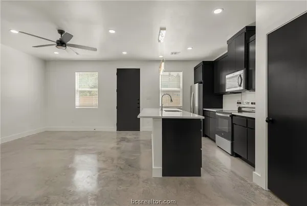 a kitchen with kitchen island a sink stainless steel appliances and cabinets